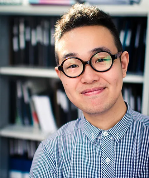 Pek Kim Beng, founder and director, smiling in front of a bookshelf